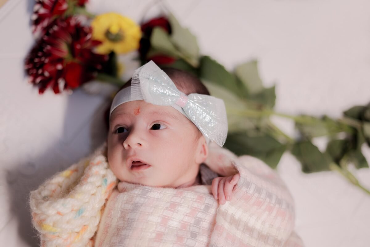 Cute newborn baby portrait with floral background and baby headband