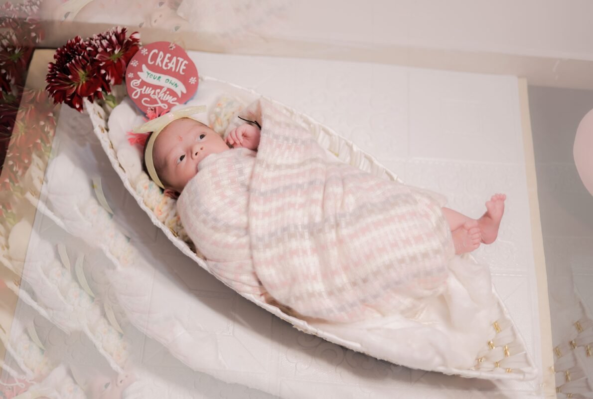 Adorable newborn baby wrapped in soft blanket during baby photoshoot