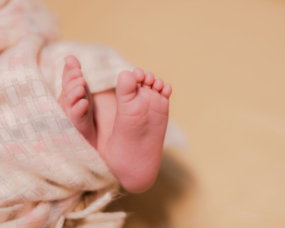 Tiny newborn baby feet close-up photography with soft background