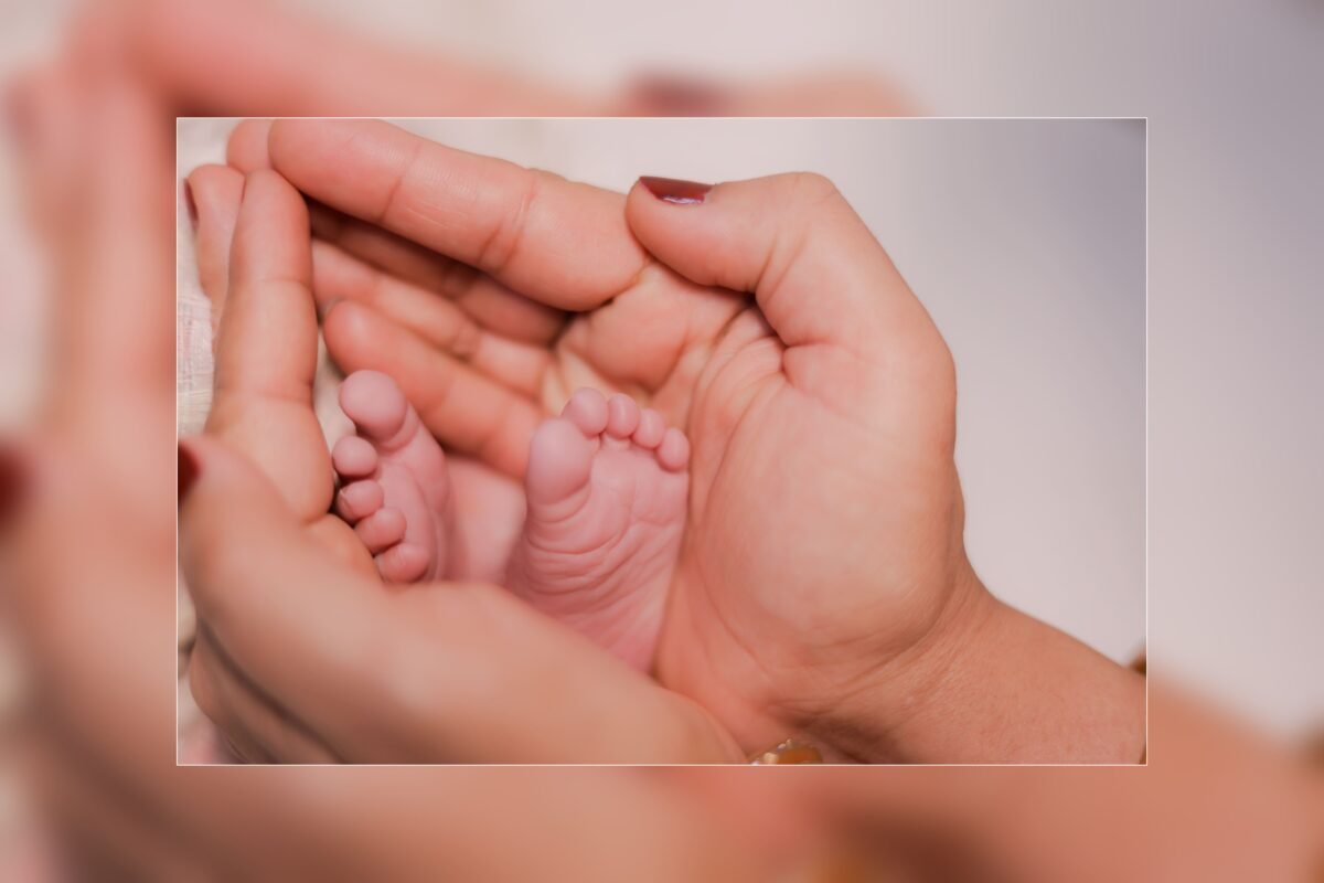 Tiny newborn baby hand holding parent finger during baby photoshoot