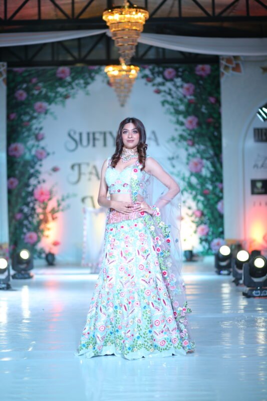 Female model walking the runway in a glamorous white designer outfit