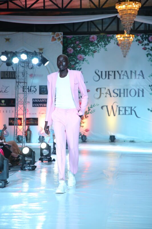Male model in pastel pink suit walking the runway at Sufiyana Fashion Week