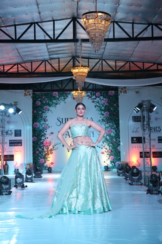 Female model posing in elegant pastel blue lehenga during ramp walk