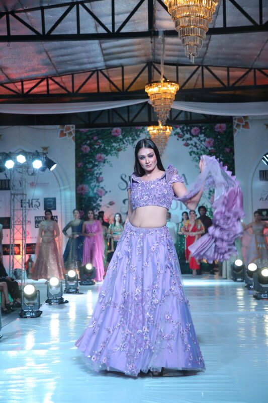 Female model carrying a modern lavender purple outfit on the ramp