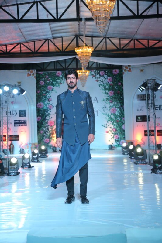 Male model walking the ramp in navy blue traditional sherwani