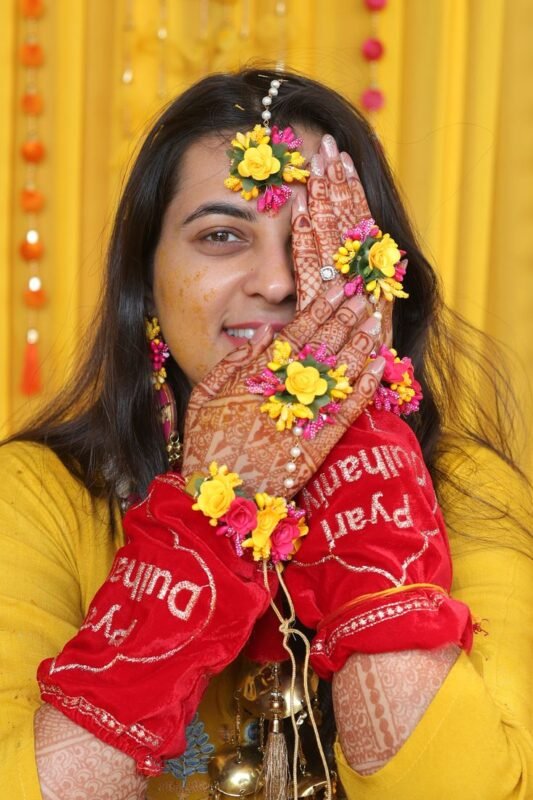 Beautiful haldi ceremony portrait of bride with floral jewelry and yellow outfit during traditional Indian wedding celebration