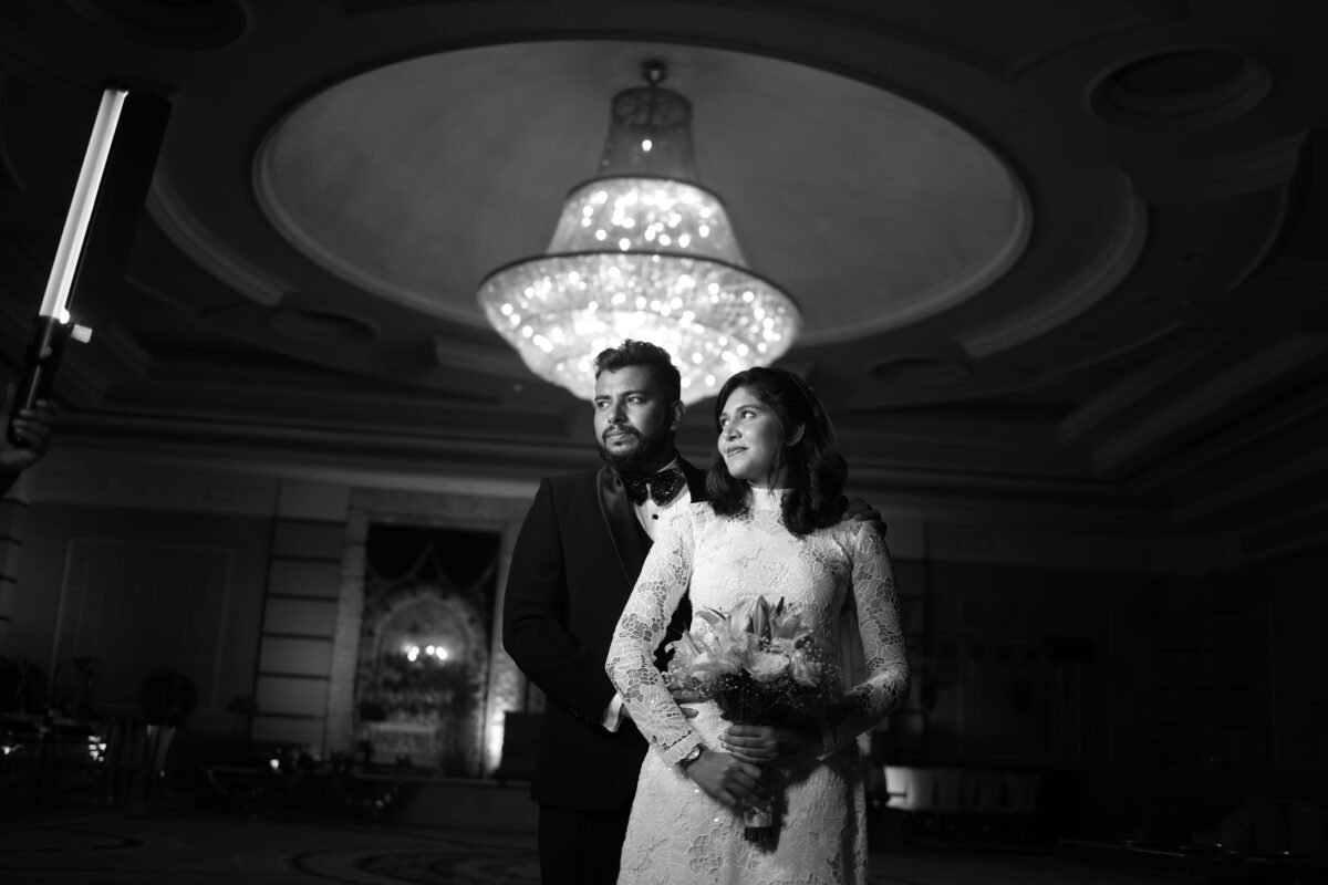 Black and white wedding couple portrait under chandelier