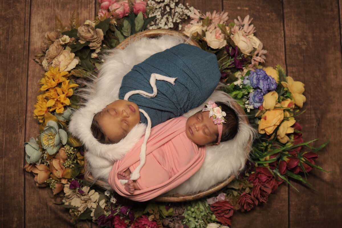 Creative twin newborn baby photoshoot with flower decoration