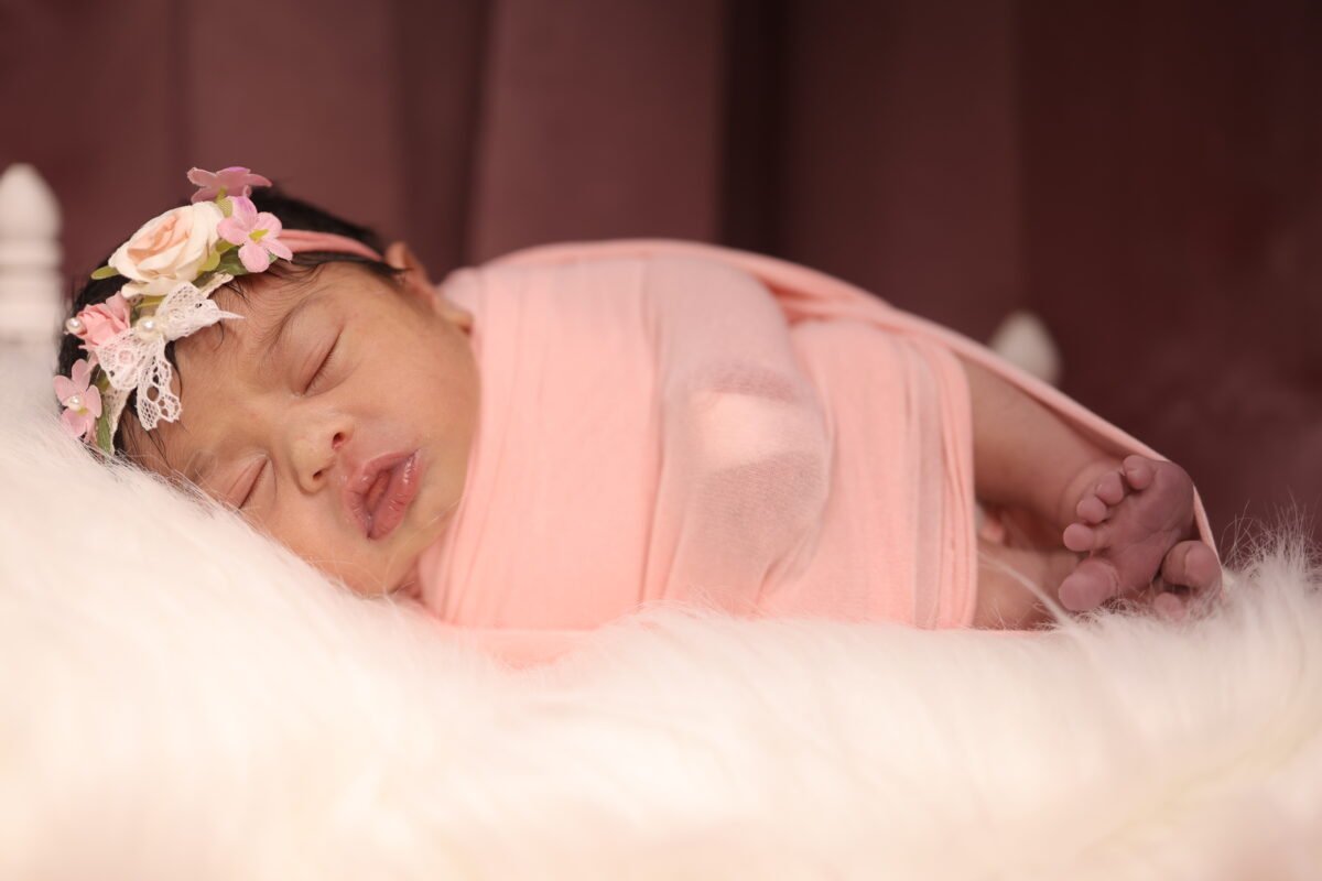 Sleeping newborn baby photoshoot in Delhi NCR with soft pink wrap by Make Your Moment Photography