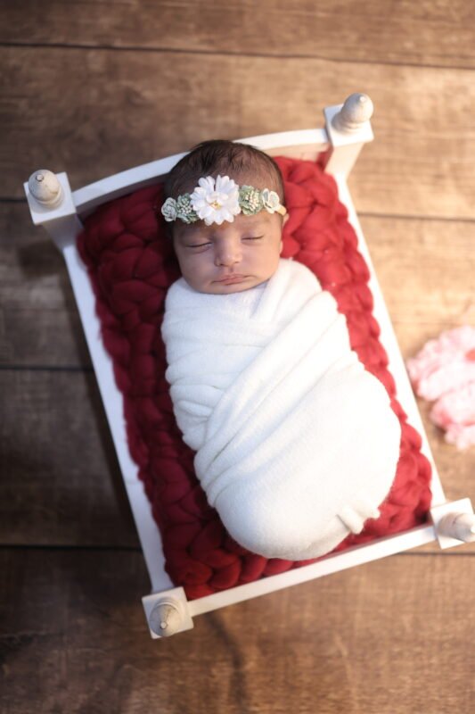 Wrapped newborn baby photography in Noida with rustic wooden setup by Make Your Moment Photography