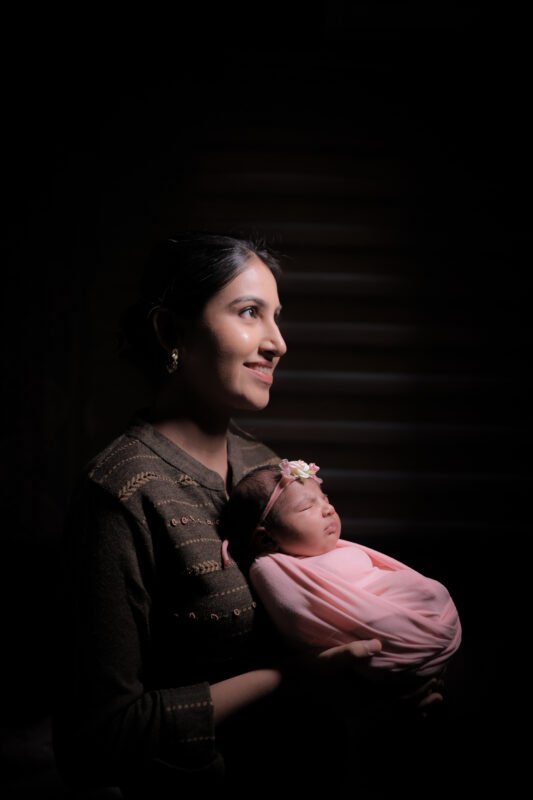 Mom holding newborn baby photoshoot in Noida