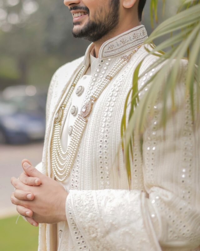 Close-up of groom wearing an embroidered sherwani.
