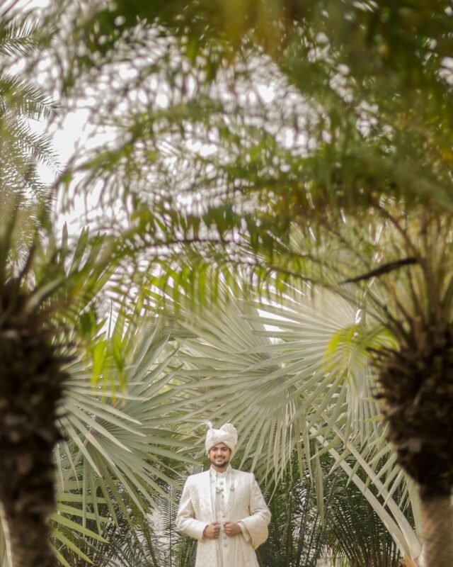 Indian groom posing in a garden.