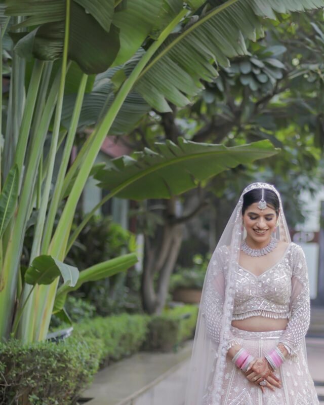 Indian bride looking down in designer lehenga.