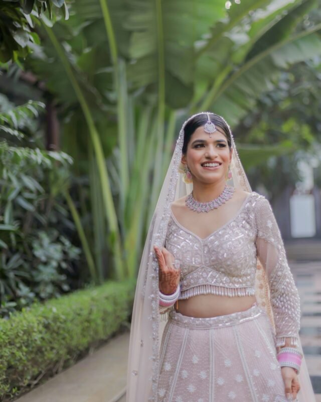 Smiling Indian bride in pastel bridal outfit.