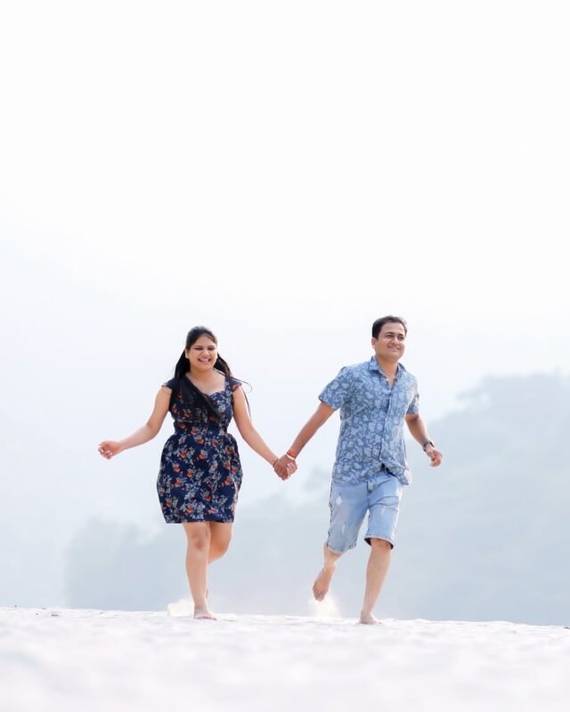 Couple walking hand in hand on the beach.