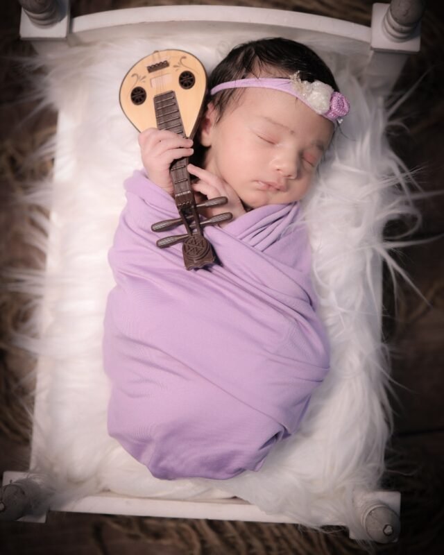 Newborn baby with musical prop