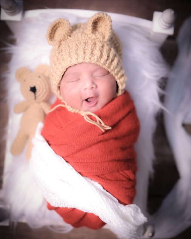 Newborn baby in red wrap