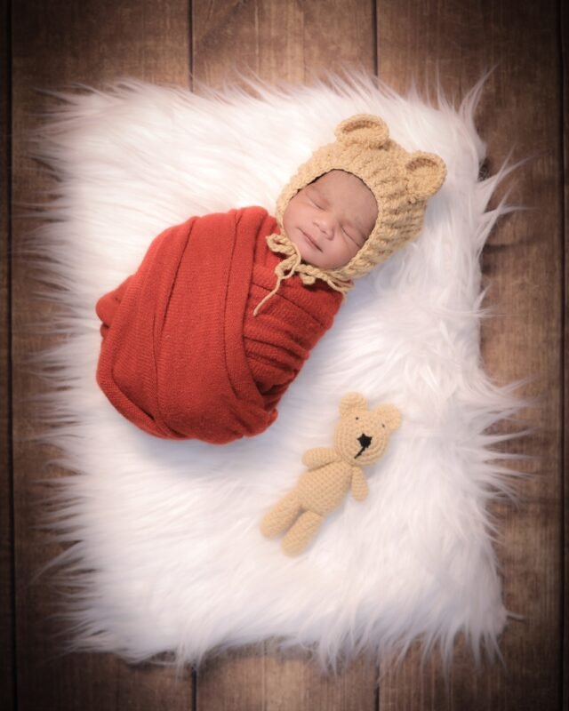 Newborn baby sleeping in red wrap
