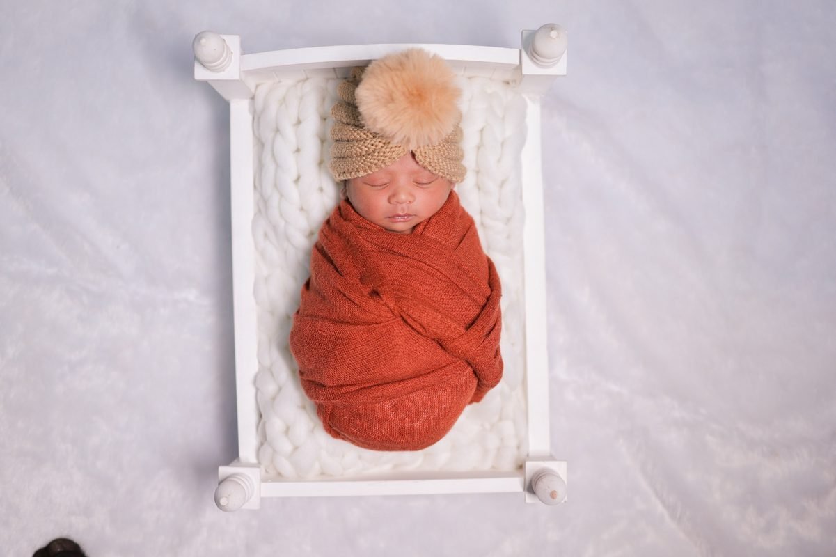 Newborn baby sleeping in white basket